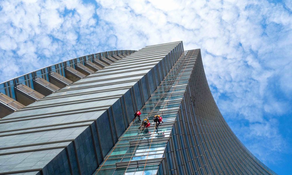 Group of Alpinists in service for windows cleaning of skyscrapers buildings